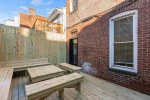 a patio with two benches on a wooden deck at Spacious, Historic Logan Circle Rowhouse in Washington