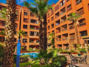 un condominio con palme e piscina di Apparts KARAMI a Marrakech