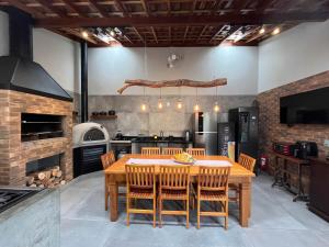 a kitchen with a wooden table and chairs at Casa na praia com churrasqueira - Bal. Camboriú in Balneário Camboriú