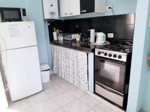 a kitchen with a stove and a refrigerator at LOS RULITOS Departamentos Temporarios in San Salvador de Jujuy