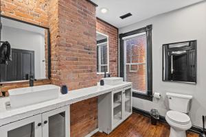 baño con 2 lavabos y pared de ladrillo en Spacious, Historic Logan Circle Rowhouse, en Washington