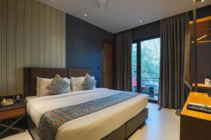 a bedroom with a large bed and a window at Hotel Bluestone - Nehru Place in New Delhi