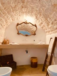 bagno con lavandino e specchio a parete di Dimore i Messapi Suites Diffuse a Ceglie Messapica