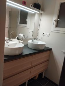 een badkamer met 2 wastafels en een spiegel bij Bienvenue in Le Cendre