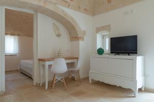 a room with a table and a tv and a bedroom at Villa Incanto con terrazza e piscina by Wonderful Italy in Ostuni