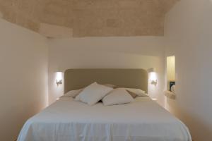 a bedroom with a white bed with two pillows at Villa Incanto con terrazza e piscina by Wonderful Italy in Ostuni +44 photos