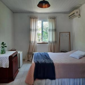 a bedroom with a large bed and a window at Sitio do Ma Vio in Governador Celso Ramos