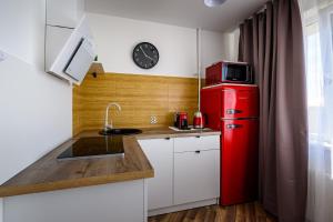 a small kitchen with a red refrigerator and a sink at SUNSET urban apartment in Liepāja