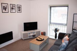 ein Wohnzimmer mit einem Sofa und einem TV in der Unterkunft ChicCityApartment - Free parking - Perfect for contractors - Close to Molineux Stadium in Wolverhampton