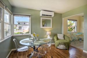 a living room with green walls and a table and chairs at Walk To Beach - EV Charger - Outdoor Dining - 2BR in Carlsbad +20 photos
