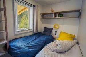 1 dormitorio con cama y ventana en Flower Camping La Sténiole, en Granges-sur-Vologne