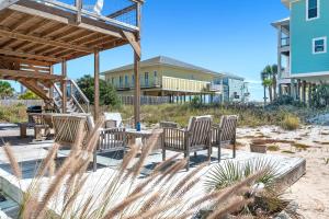 een groep stoelen en een tafel op het strand bij Aquaverde Beach House in Pensacola Beach