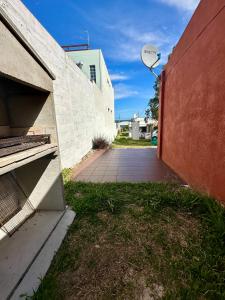 eine Backsteinmauer mit einem Basketballkorb neben einem Gebäude in der Unterkunft Casa Alquiler Cuchilla Alta 2 in Cuchilla Alta