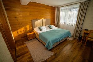特尔斯泰纳奥拉瓦树林花园度假酒店的卧室里有一张床，墙是木的