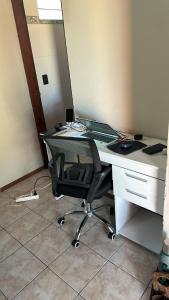 ein Büro mit einem Schreibtisch mit einem Stuhl und einem Spiegel in der Unterkunft Casa Alquiler Cuchilla Alta 2 in Cuchilla Alta