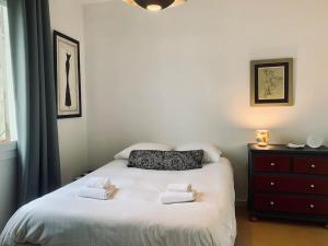 een slaapkamer met een bed met handdoeken erop bij Le Saint HeL, Magnifique T2 en face du TNB in Rennes