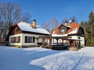dom ze śniegiem na ziemi przed nim w obiekcie Chaloupka u řeky w mieście Frydlant nad Ostrawicą