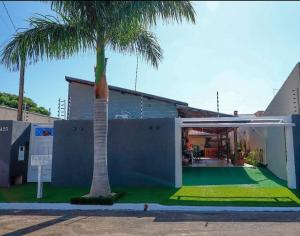 een huis met een palmboom ervoor bij Rubi casa de temporada com piscina aquecida e área gourmet in Santa Fé do Sul