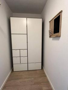 um quarto com um armário branco com uma porta em Gemütlichkeit mit Cityblick em Leipzig