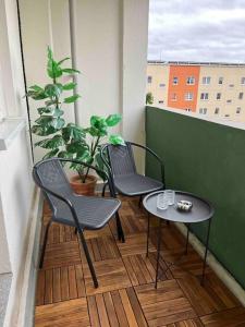 Duas cadeiras e uma mesa numa varanda em Gemütlichkeit mit Cityblick em Leipzig