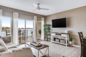 ein Wohnzimmer mit Sofa und Flachbildfernseher in der Unterkunft Beach N' Bay in Pensacola Beach