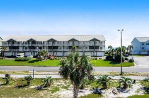 ein großes Gebäude mit Palmen vor einer Straße in der Unterkunft Beach N' Bay in Pensacola Beach