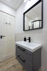 een badkamer met een witte wastafel en een spiegel bij Budapest Holidays OPERArt in Boedapest