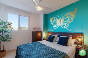 1 dormitorio con 1 cama con una mariposa en la pared en Beachfront apartment - terrace with sea view - pool, en Algarrobo