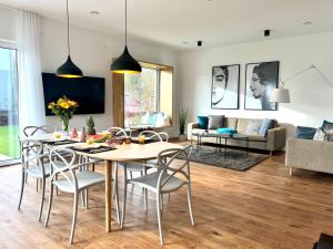 comedor y sala de estar con mesa y sillas en Luxus-Ferienhaus mit Saunen und großem Garten en Göhren-Lebbin