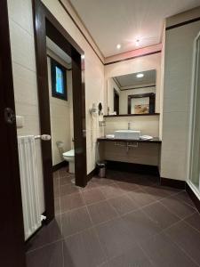 a bathroom with a sink and a toilet and a mirror at LA CANTUEÑA in Madrid