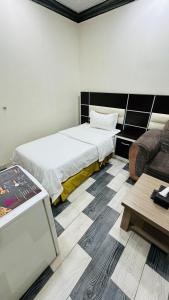 أجنحة بلو روز الفندقية في نجران: غرفة نوم بسرير كبير وأريكة