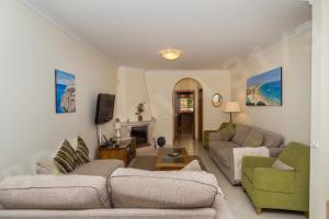 een woonkamer met 2 banken en een open haard bij Boa Nova Plot 3 apt 31 in Carvoeiro