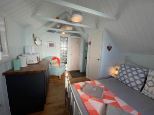 Un pequeño dormitorio con una cama y una cocina. en Cilia Marys Annexe St Teath, en Saint Teath