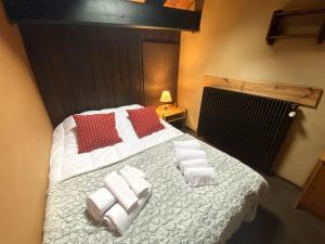 1 dormitorio con 1 cama con toallas en LA POMME DE PIN 1 Appartement avec terrasse, en La Bresse