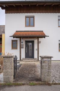 ein weißes Haus mit einer schwarzen Tür in der Unterkunft Ferienwohnung AusZeit 2 in Ainring