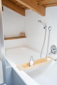 eine Badewanne mit Duschkopf und einem Holztablett in der Unterkunft Ferienwohnung AusZeit 2 in Ainring