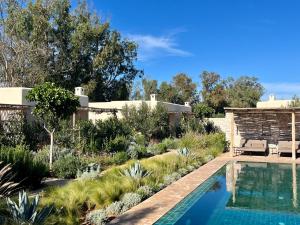 a garden with a swimming pool and a house at Maison Flamingo - Boutique hôtel in Essaouira