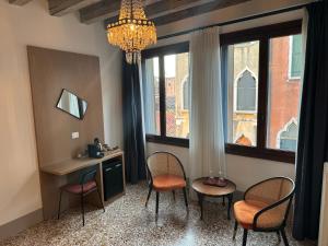 a room with chairs and a desk and a chandelier at TRA SAN MARCO E RIALTO in Venice