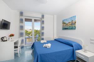 una camera con un letto blu e una finestra di B&B La Vigna Rooms - Ischia Ponte a Ischia