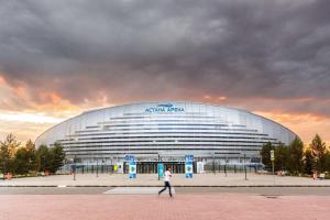 a person walking in front of a large building at ЖК Чемпион in Taldykolʼ