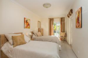 um quarto branco com 2 camas e uma janela em Boa Nova 31/2 em Carvoeiro