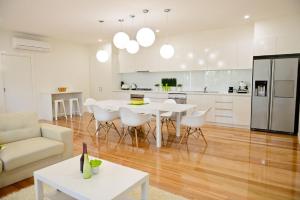 a kitchen and living room with a table and chairs at 7 Gilmore Street, Smiths Beach in Smiths Beach