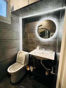 a bathroom with a toilet and a sink and a mirror at eliTe deluxe in Kavála