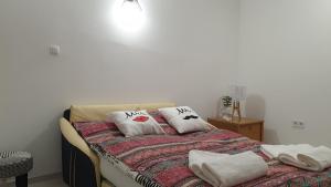 Una cama con dos almohadas encima. en Vár-i Apartman, en Balatonmáriafürdő