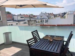 uma mesa e cadeiras numa varanda com um guarda-sol em Rooftop apartment in and over Vienna em Viena