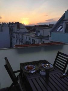 uma varanda com uma mesa com duas pizzas em Rooftop apartment in and over Vienna em Viena