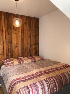 1 dormitorio con 1 cama con pared de madera en Rooftop apartment in and over Vienna, en Viena