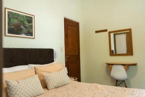 1 dormitorio con cama con almohadas y espejo en Coliving Med by Hotel Mediterràneo en Montevideo