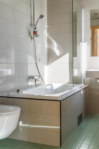 a bathroom with a tub and a toilet and a sink at Fritiden Hotell & Kongress in Ystad