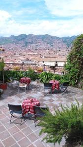 a patio with tables and chairs and a view of a city at Kutty Wasi in Cusco